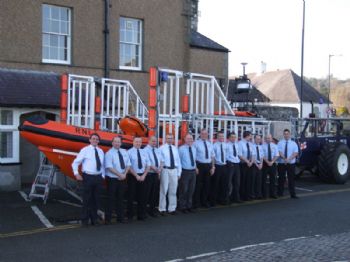 Members of the Beaumaris RNLI team and the new Atlantic 85 lifeboat outside the Royal Anglesey Yacht Club
